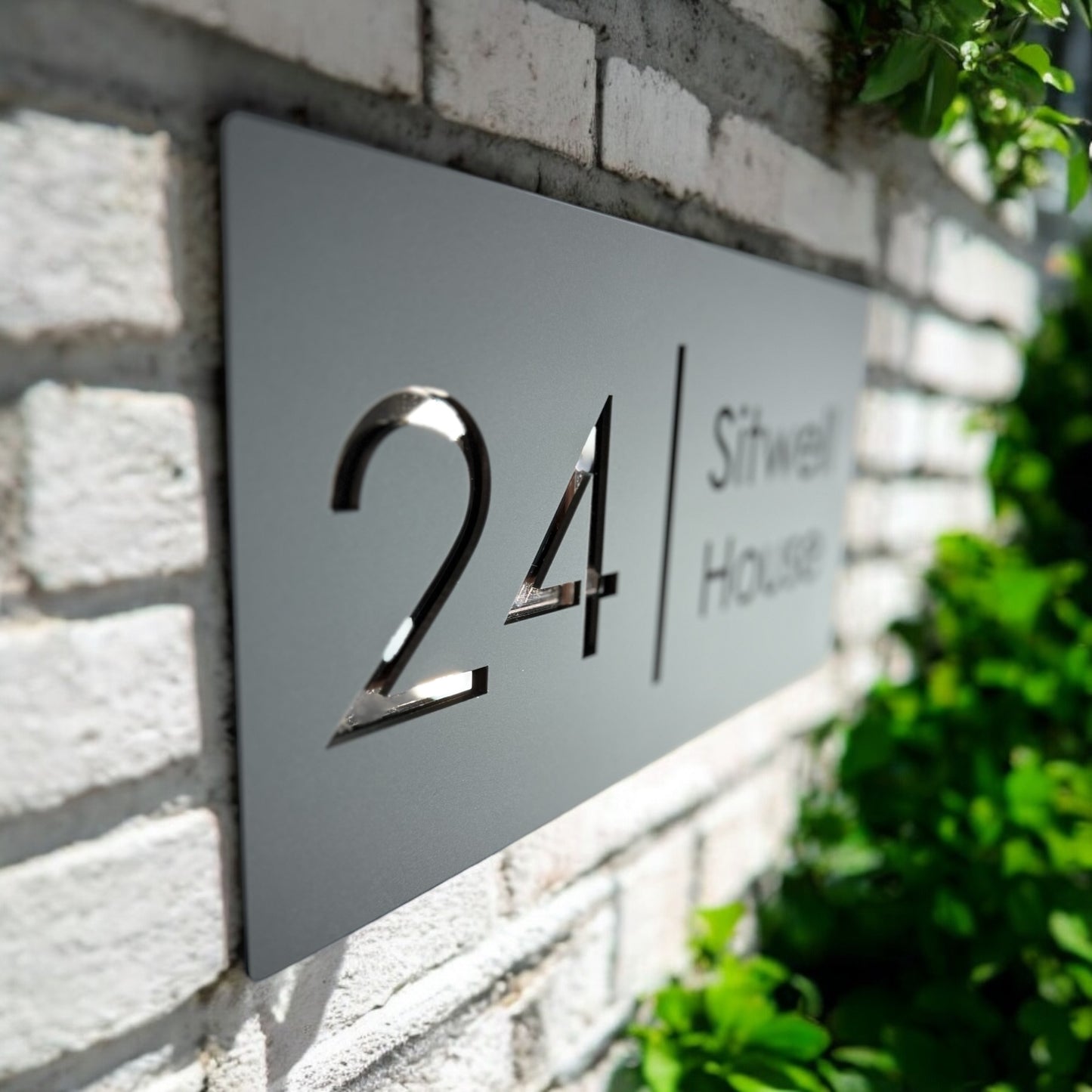 Close-up of 3D acrylic house sign with rose gold mirror base