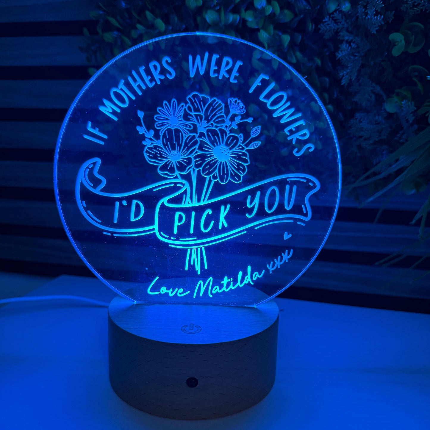 Wall-mounted night light with engraved text and floral design on a blue background