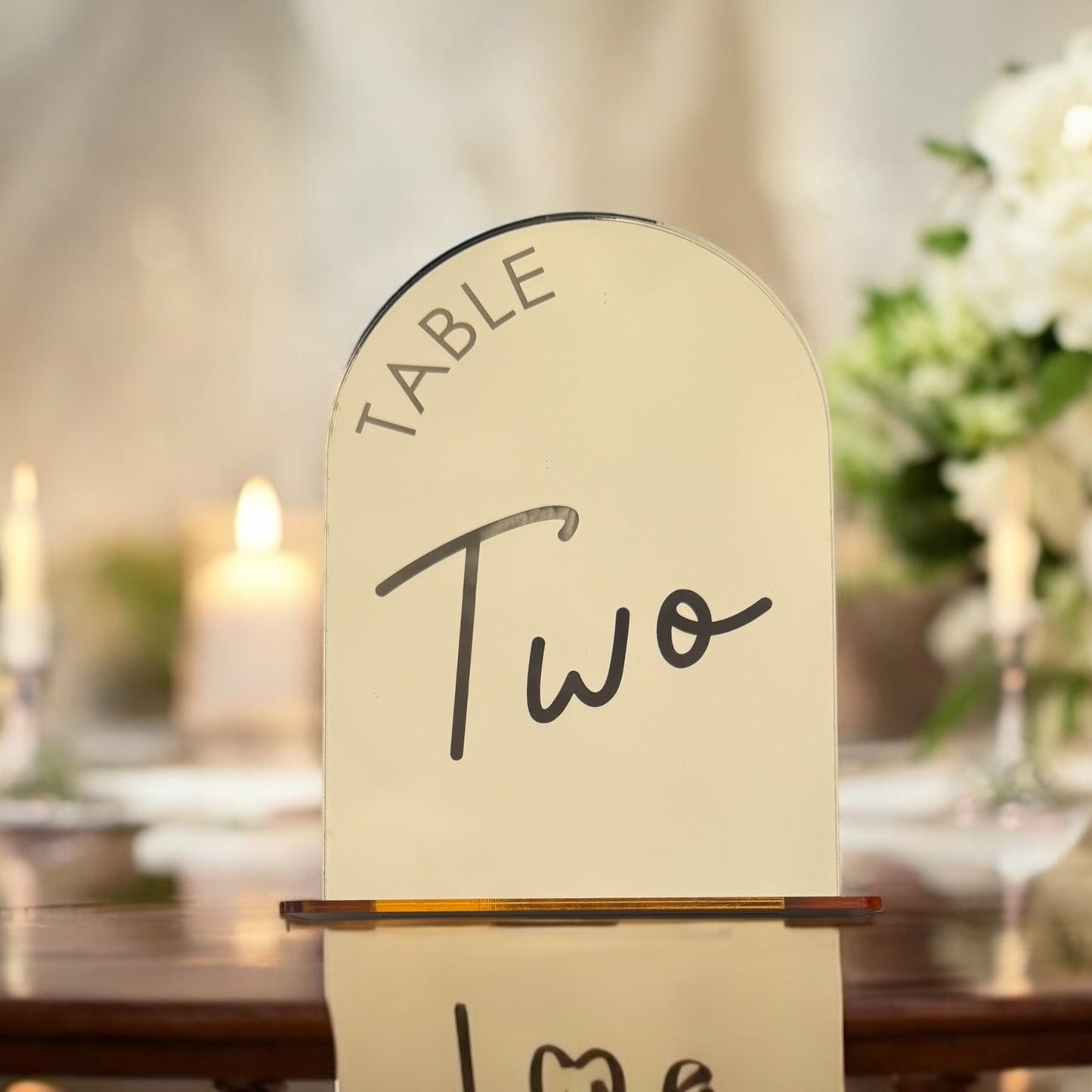 Close-up of two font options for mirror arch table numbers in gold