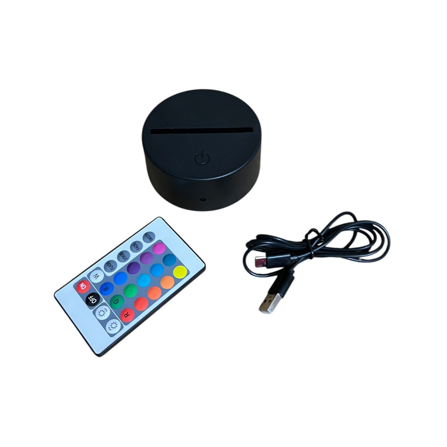 Black round LED light, remote control with color buttons, and USB cable on a white background