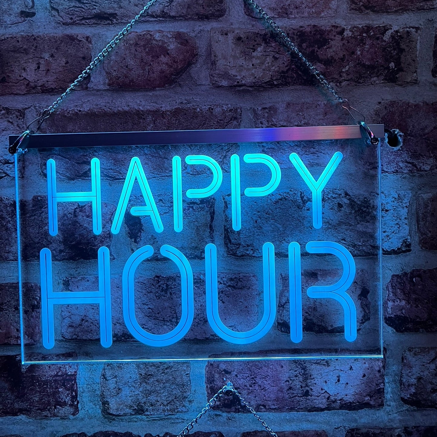 Happy Hour LED sign mounted on a wall, glowing in multiple colours.