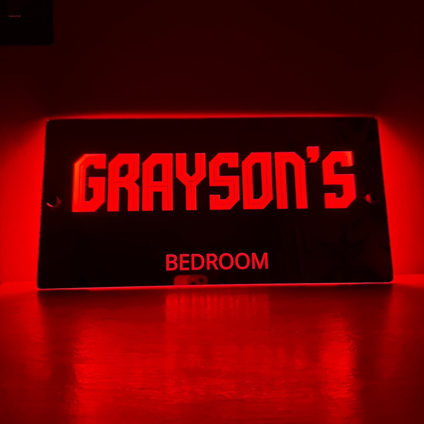 Softly lit LED mirror sign in a child’s bedroom at night, creating a cosy and magical atmosphere