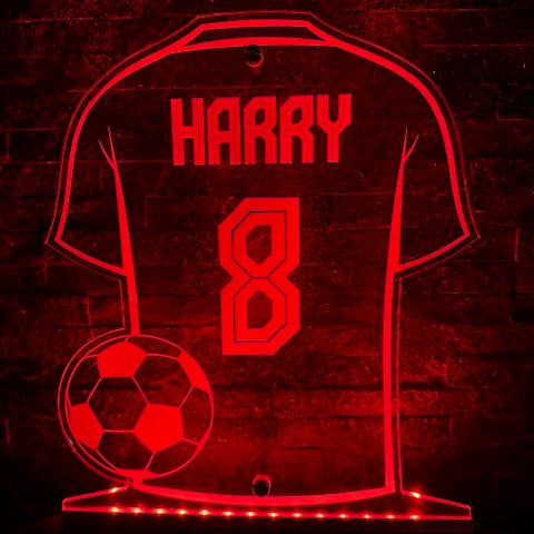 Glowing LED football sign displaying custom design in a dark room.