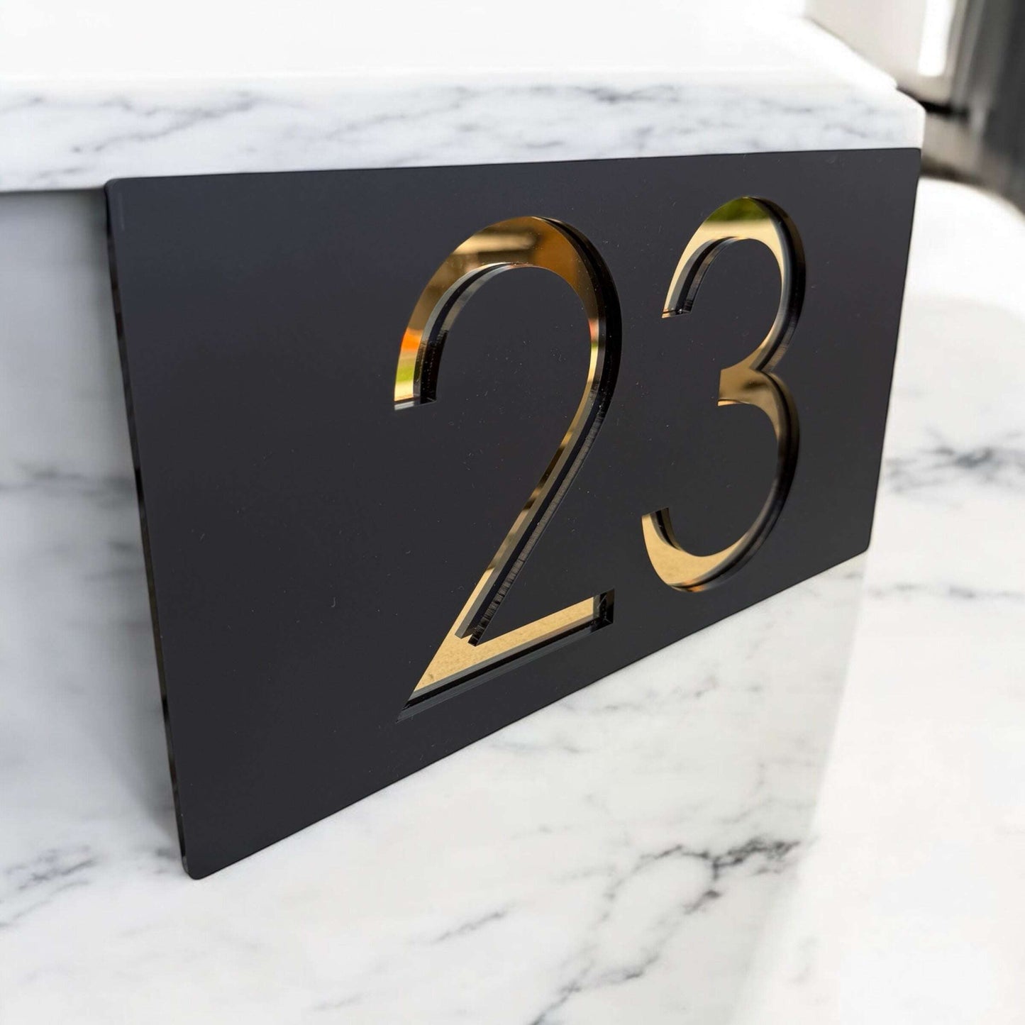 Elegant gold and black layered house number sign for home entrances