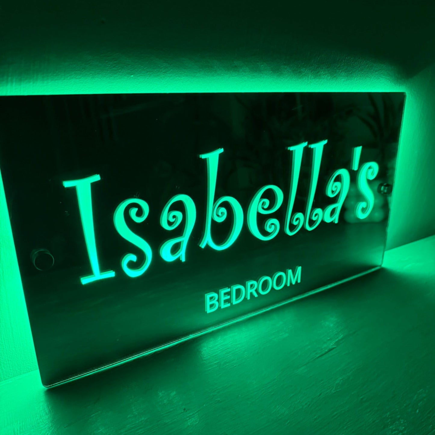 Custom LED mirror sign mounted on a pink bedroom wall, adding a magical glow to a girl's room.