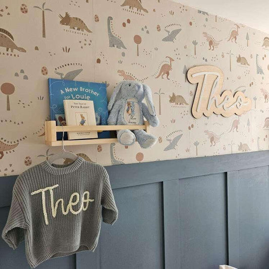Flat lay of personalised nursery gifts including a wooden name sign, and night light.