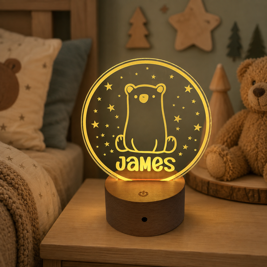A personalized 3D optical illusion night light shaped like a bear under a starry sky, glowing with warm yellow light on a wooden base in a cozy bedroom setting.