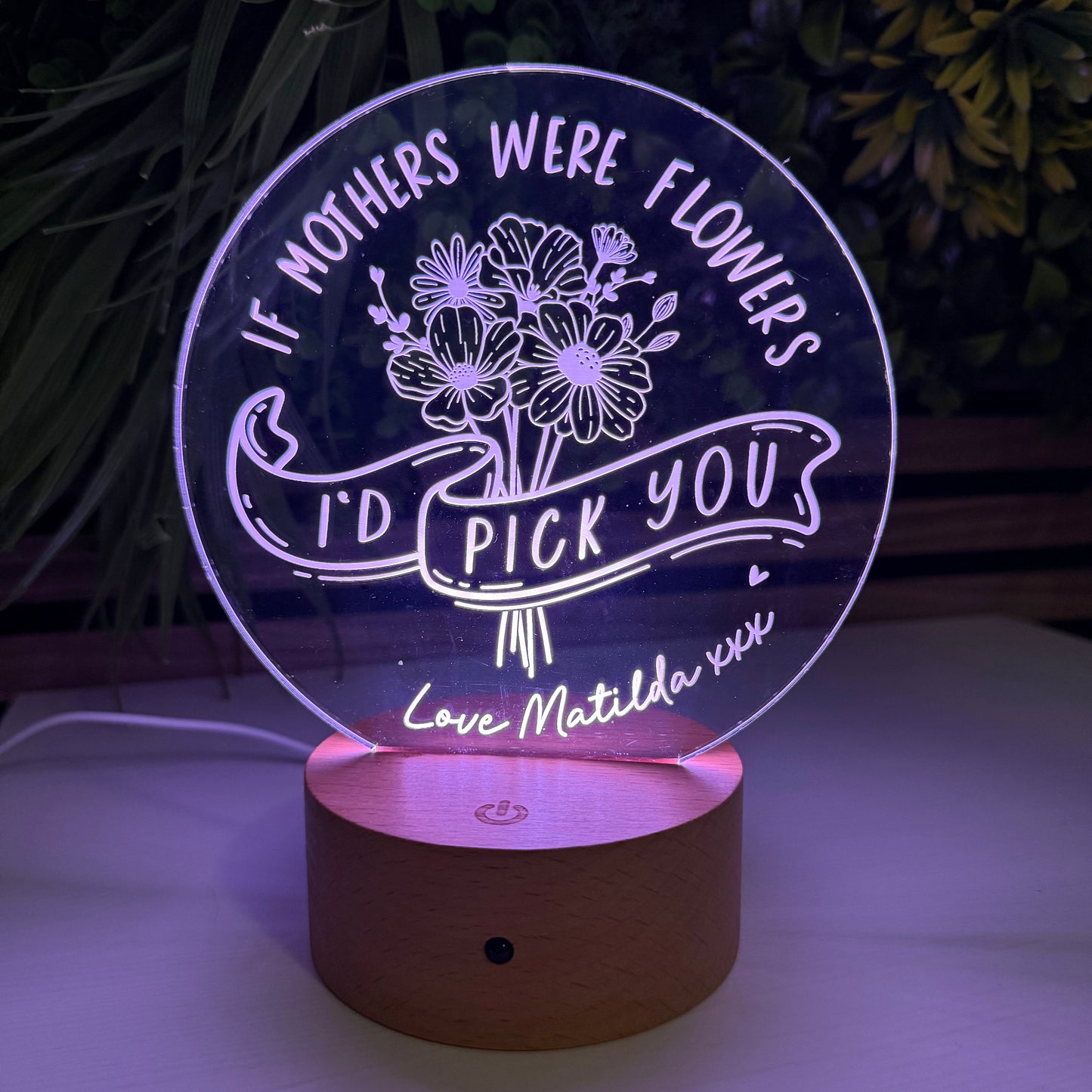 Decorative night light with floral design and text on a dark background