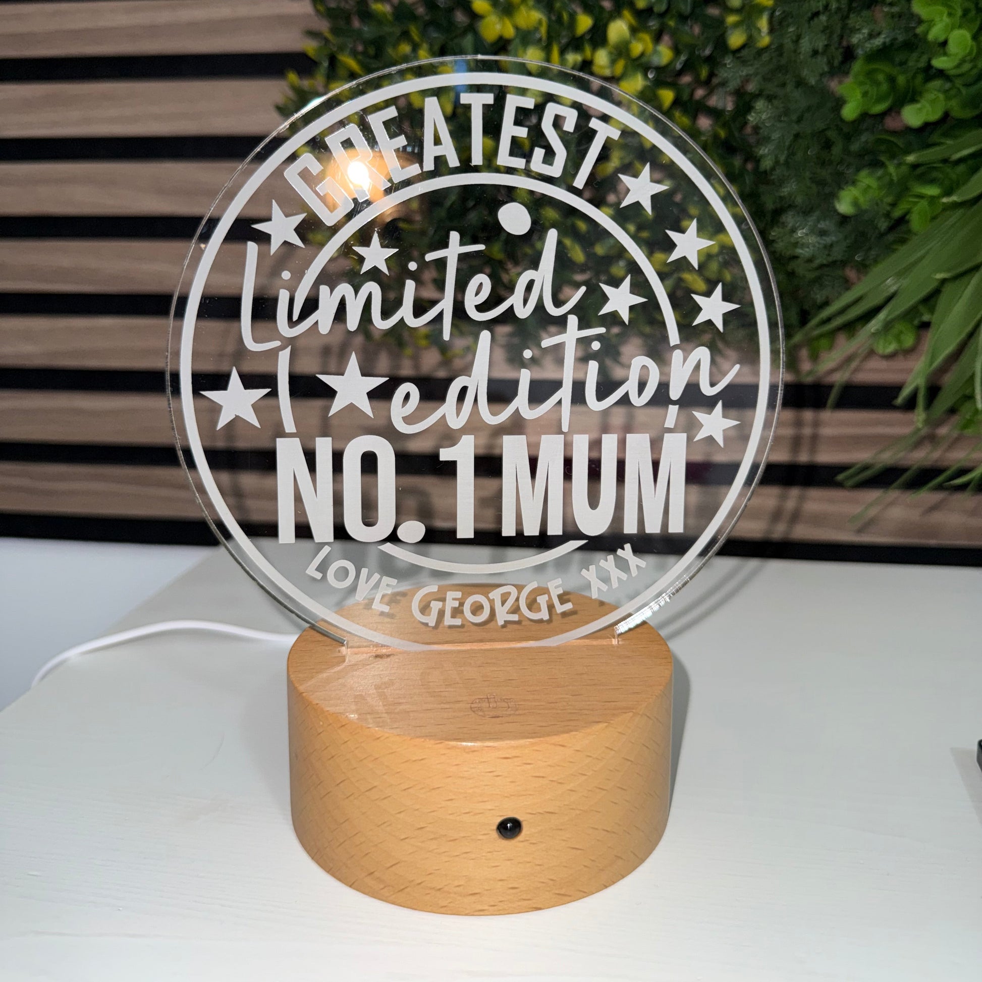 Decorative wall light with 'Greatest Limited Edition No. 1 Mum' text on a white wall.