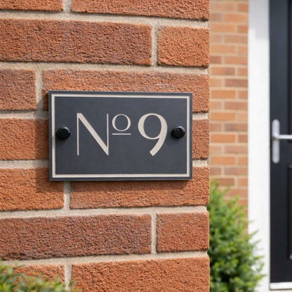 House number 'No 9' on a brick wall