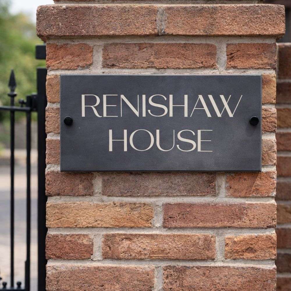 Brick wall with a sign reading 'Renishaw House'