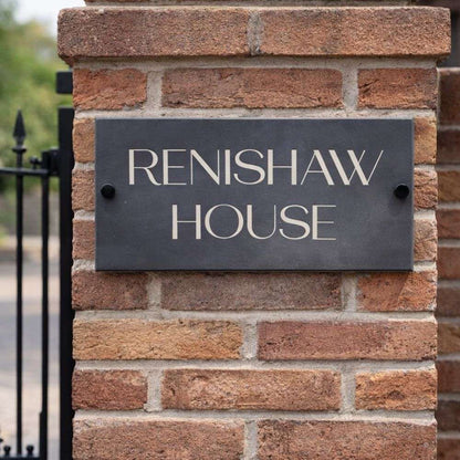 Brick wall with a sign reading 'Renishaw House'