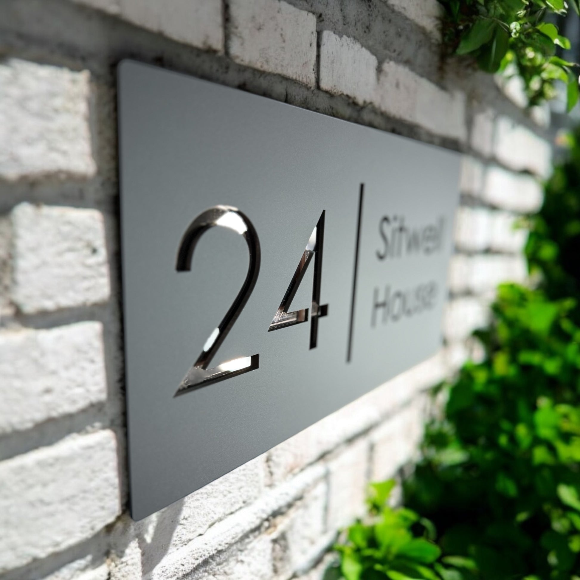 Close-up of 3D acrylic house sign with rose gold mirror base