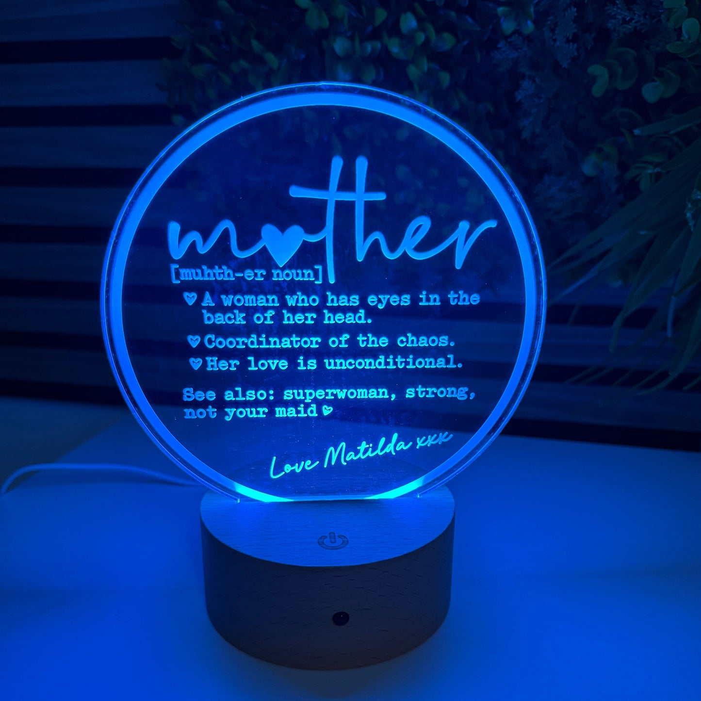 Decorative night light with 'Mother' text on a white wall.