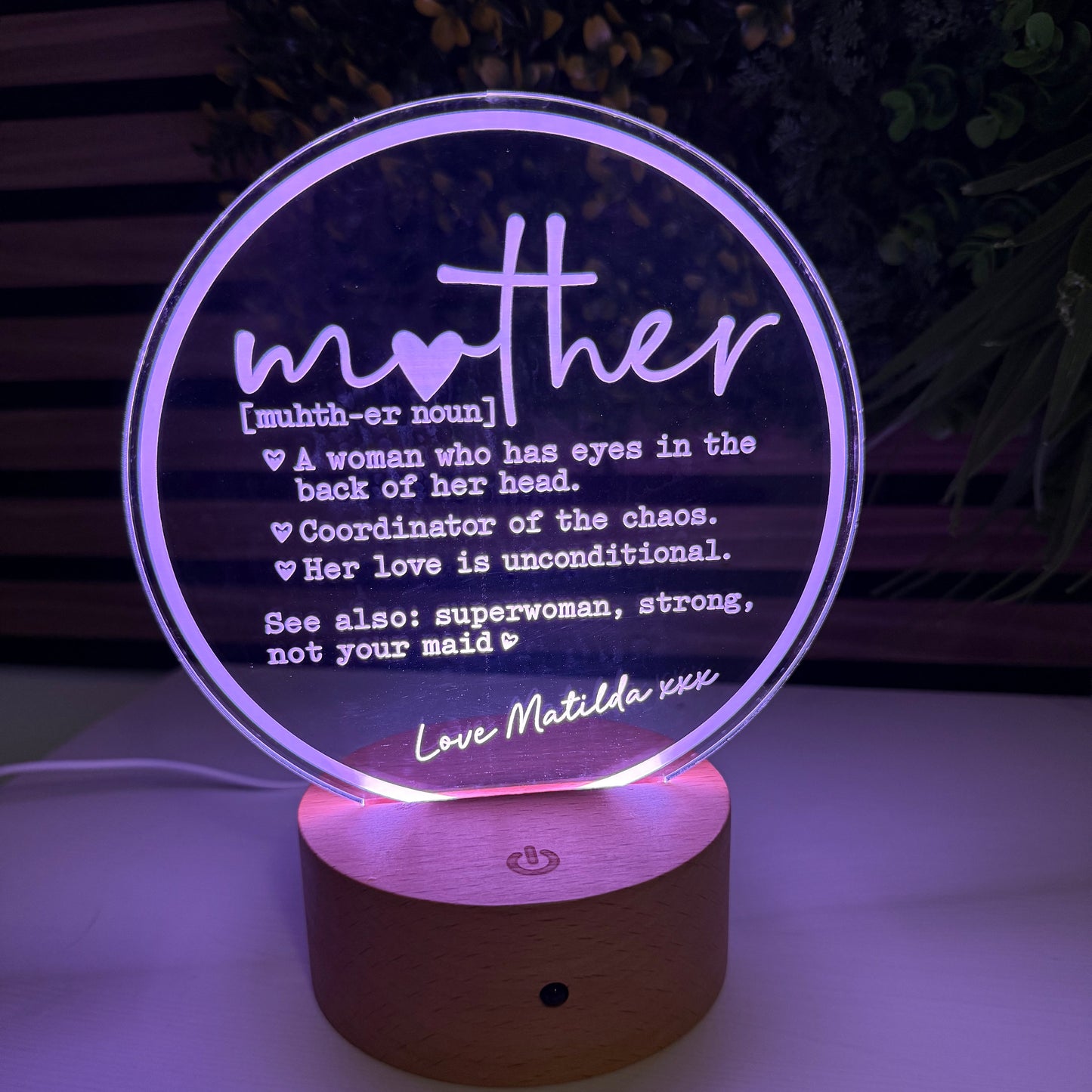 Decorative night light with 'mother' definition text on a dark background