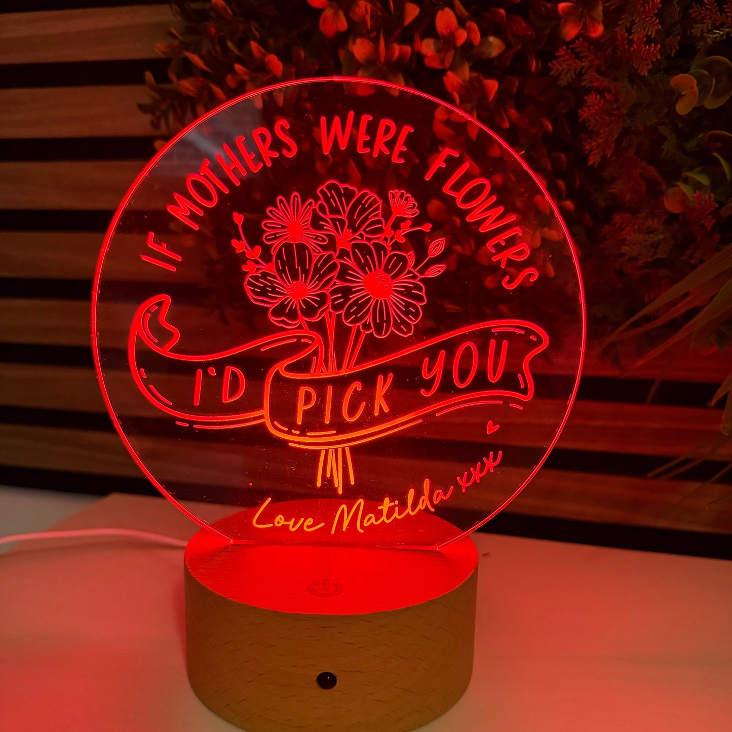 Decorative night light with floral design and text on a wall.