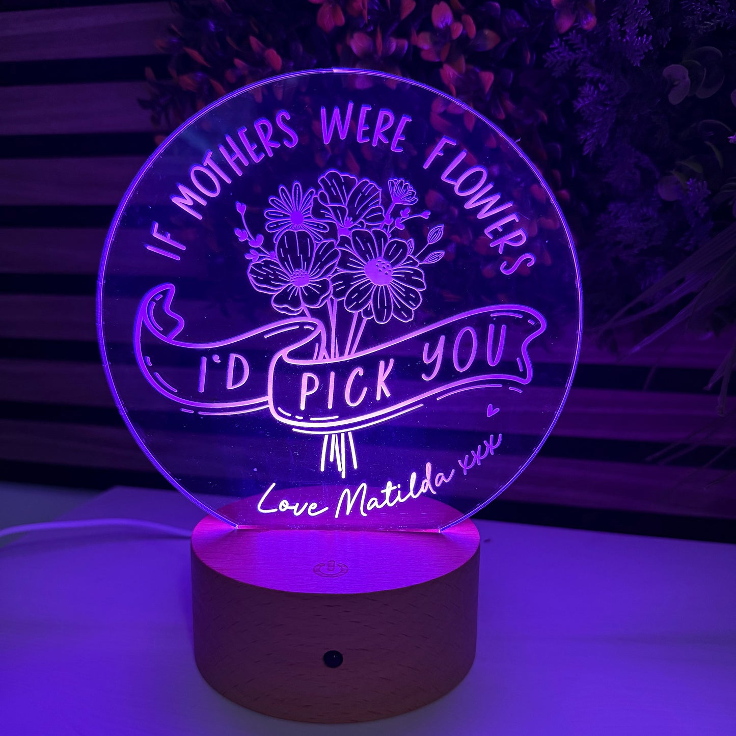 Decorative night light with floral design and text on a wall.