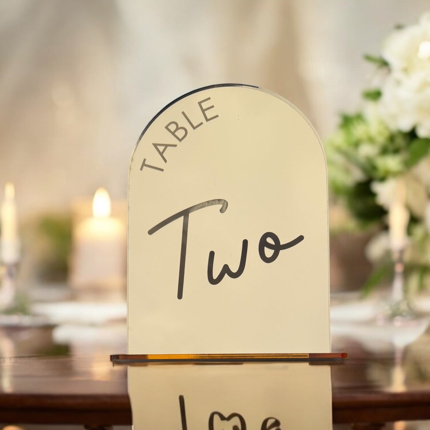 Close-up of two font options for mirror arch table numbers in gold