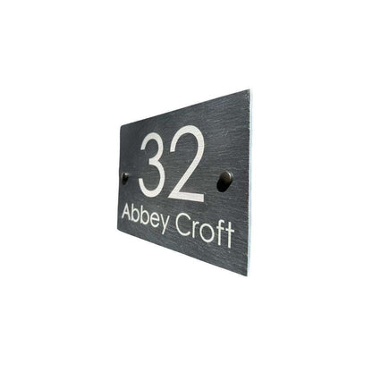 Black house number sign with '32 Abbey Croft' on a white background