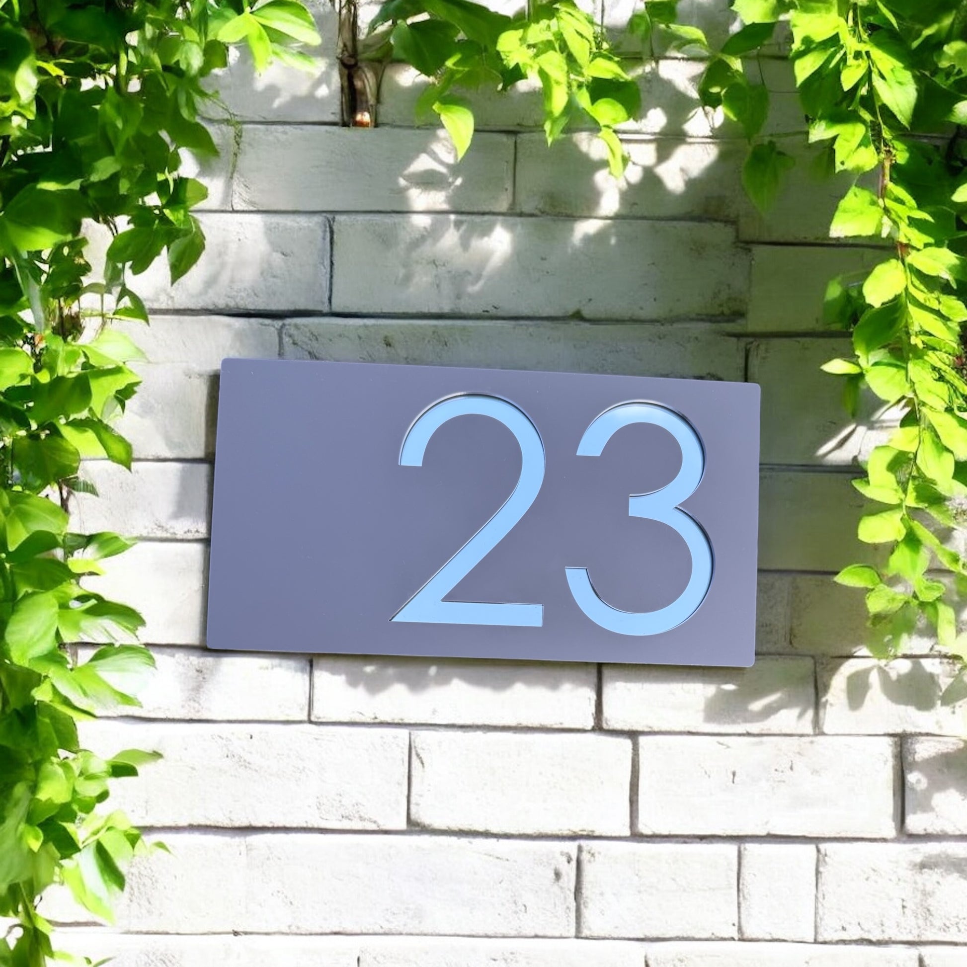 Close-up of mirror acrylic reflecting sunlight on house sign