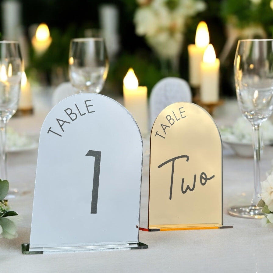 Close-up of two font options for mirror arch table numbers in gold and silver