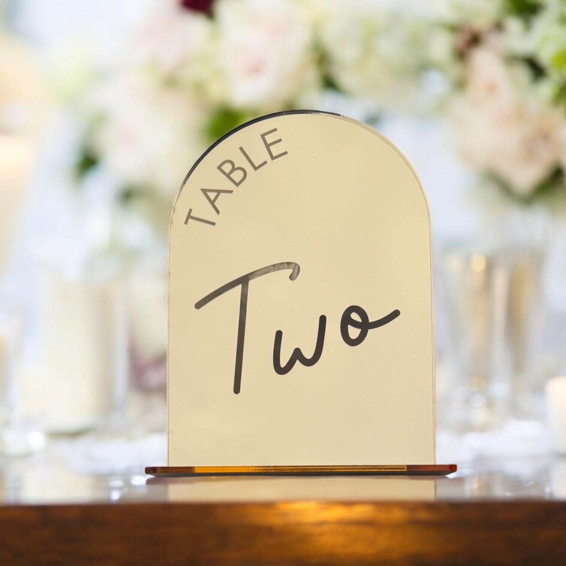 Side view of silver mirror acrylic arch table number