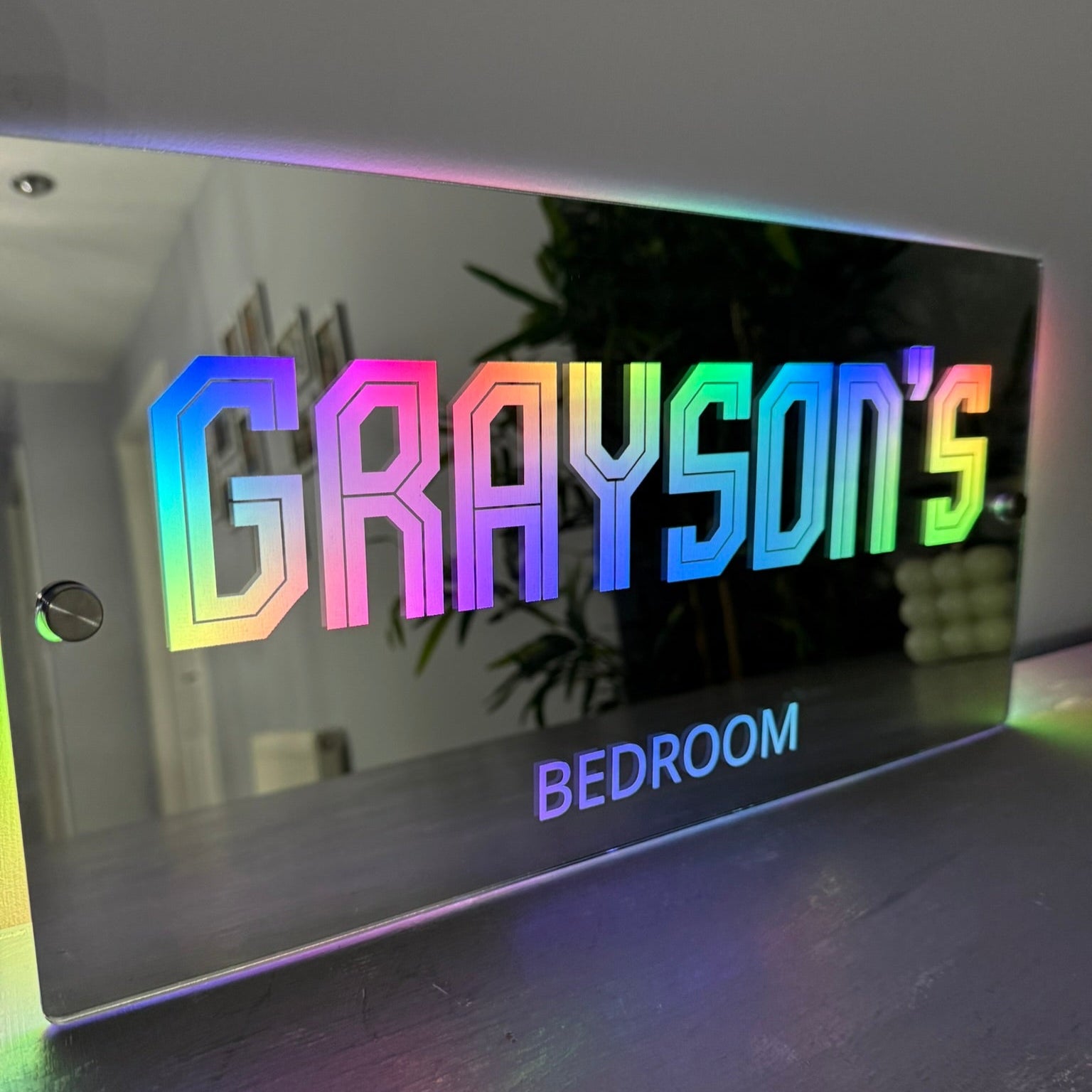 Personalised LED mirror sign with name illuminated in multicolour lights, perfect for children’s bedroom decor